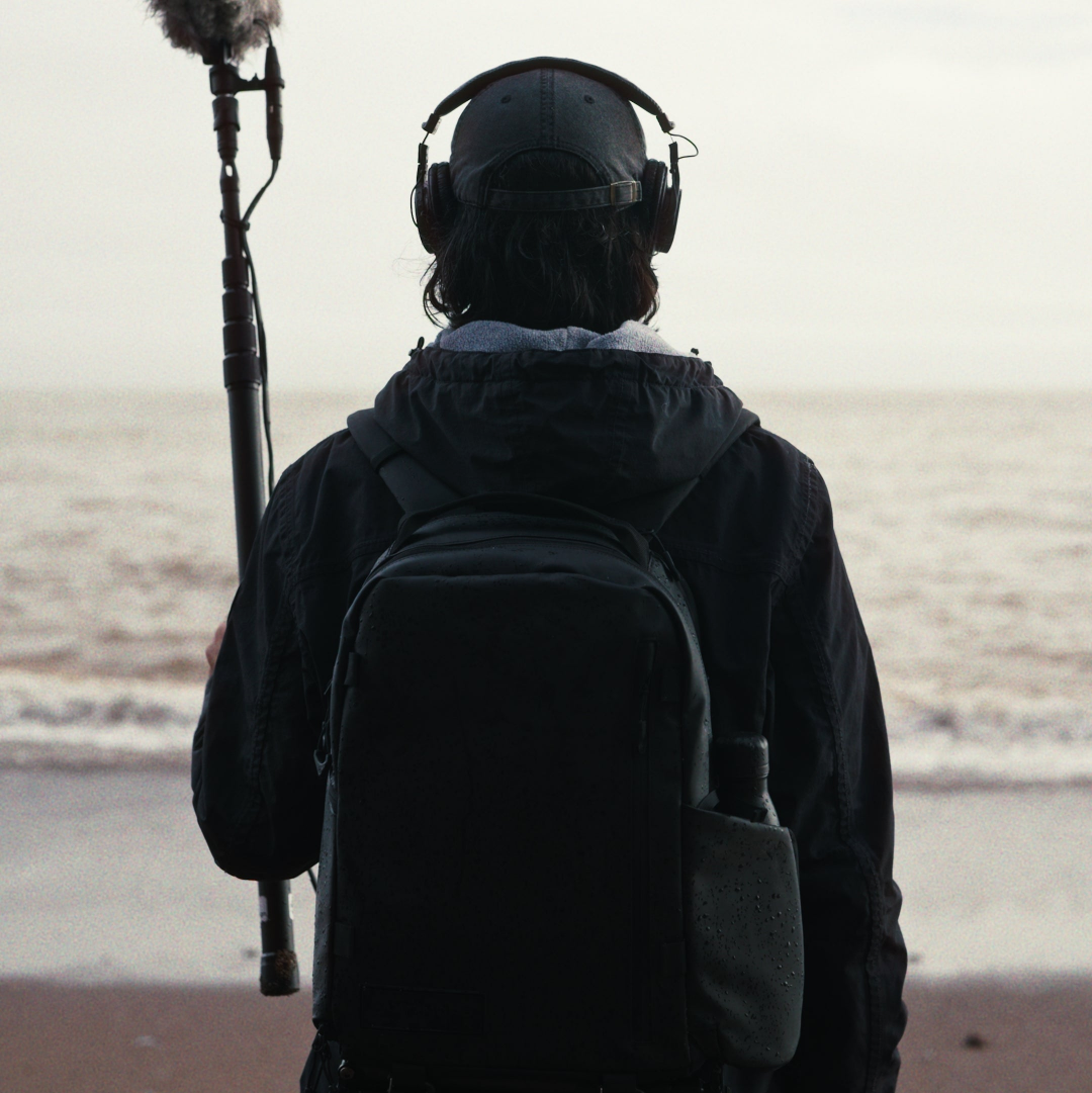 Person with audio recording equipment on a beach